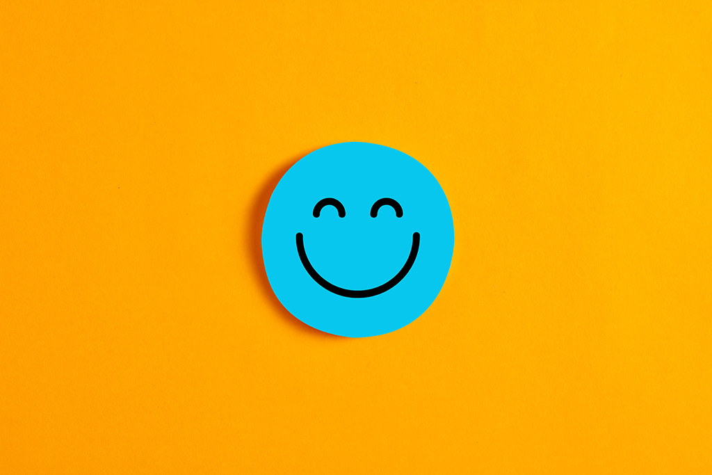 Blue round circle with a happy or smiley face icon on it against